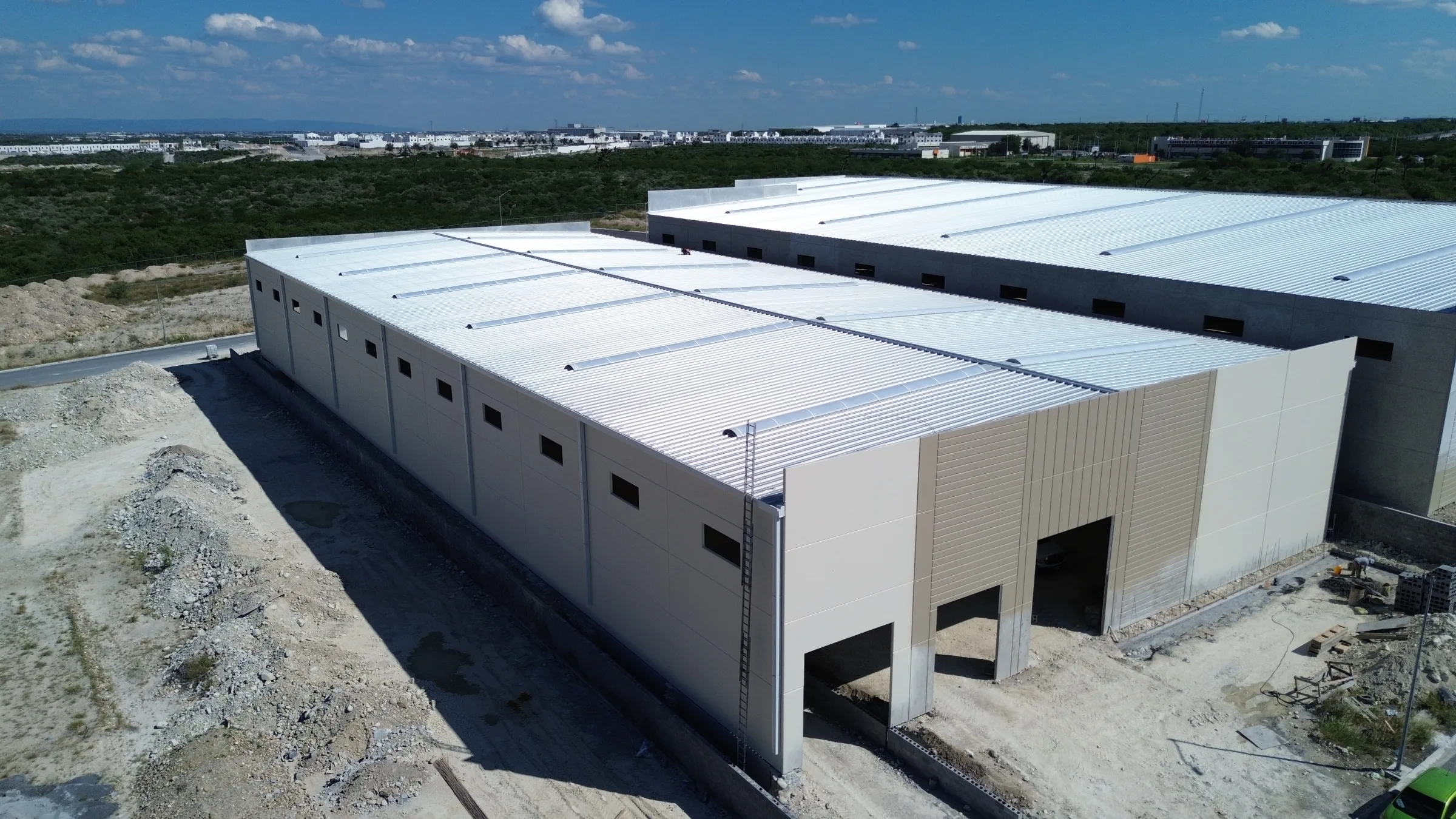 Nave industrial terminada con fachada clara de lámina de muro